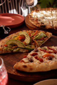 Close-up of gourmet veggie and cheese pizzas on wooden boards, perfect for food lovers.