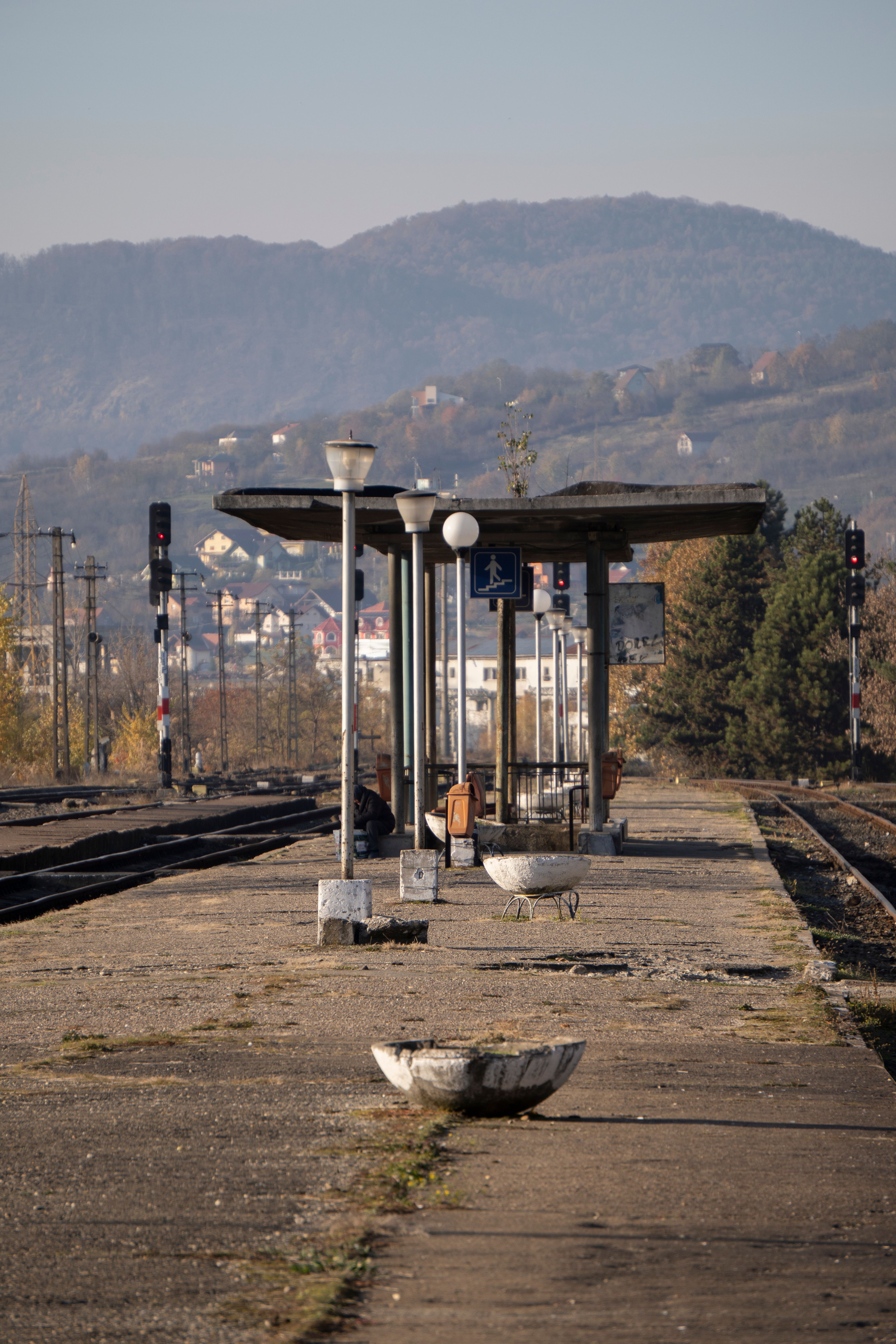 Old train station in Baia Mare, Romania during autumn with scenic hills in background.
