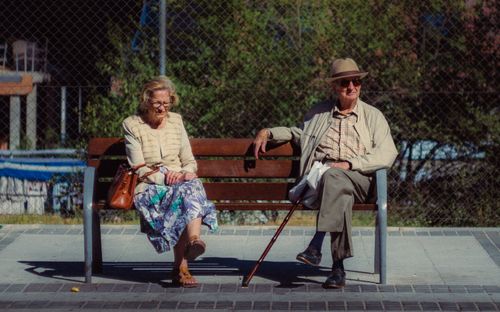 Free Senior couple enjoying a sunny day on a park bench in Arganda del Rey, Spain. Stock Photo