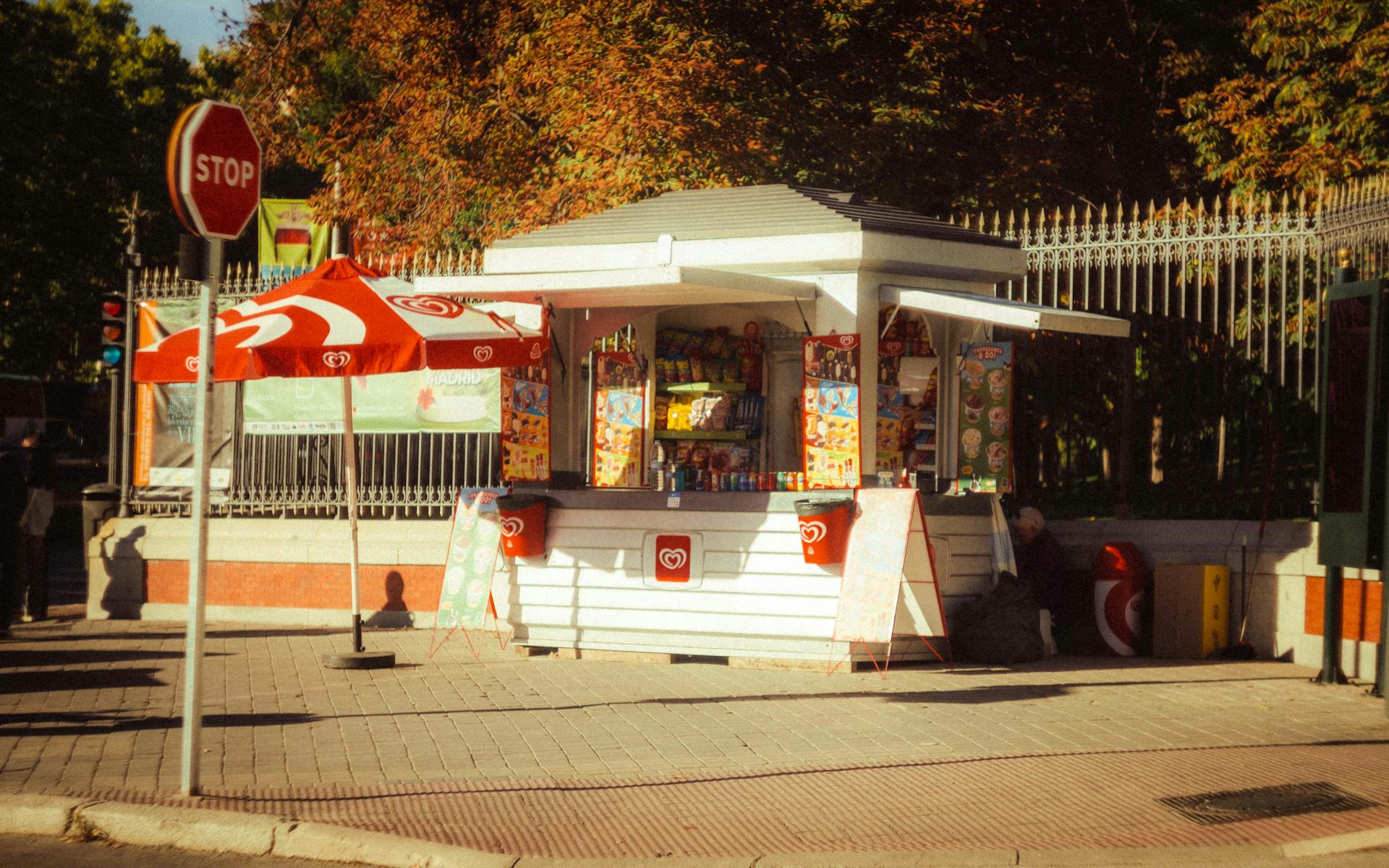 Retro-style snack kiosk on a sunny Madrid street.