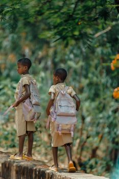 Two children walking on a nature path with backpacks, showcasing exploration and adventure.
