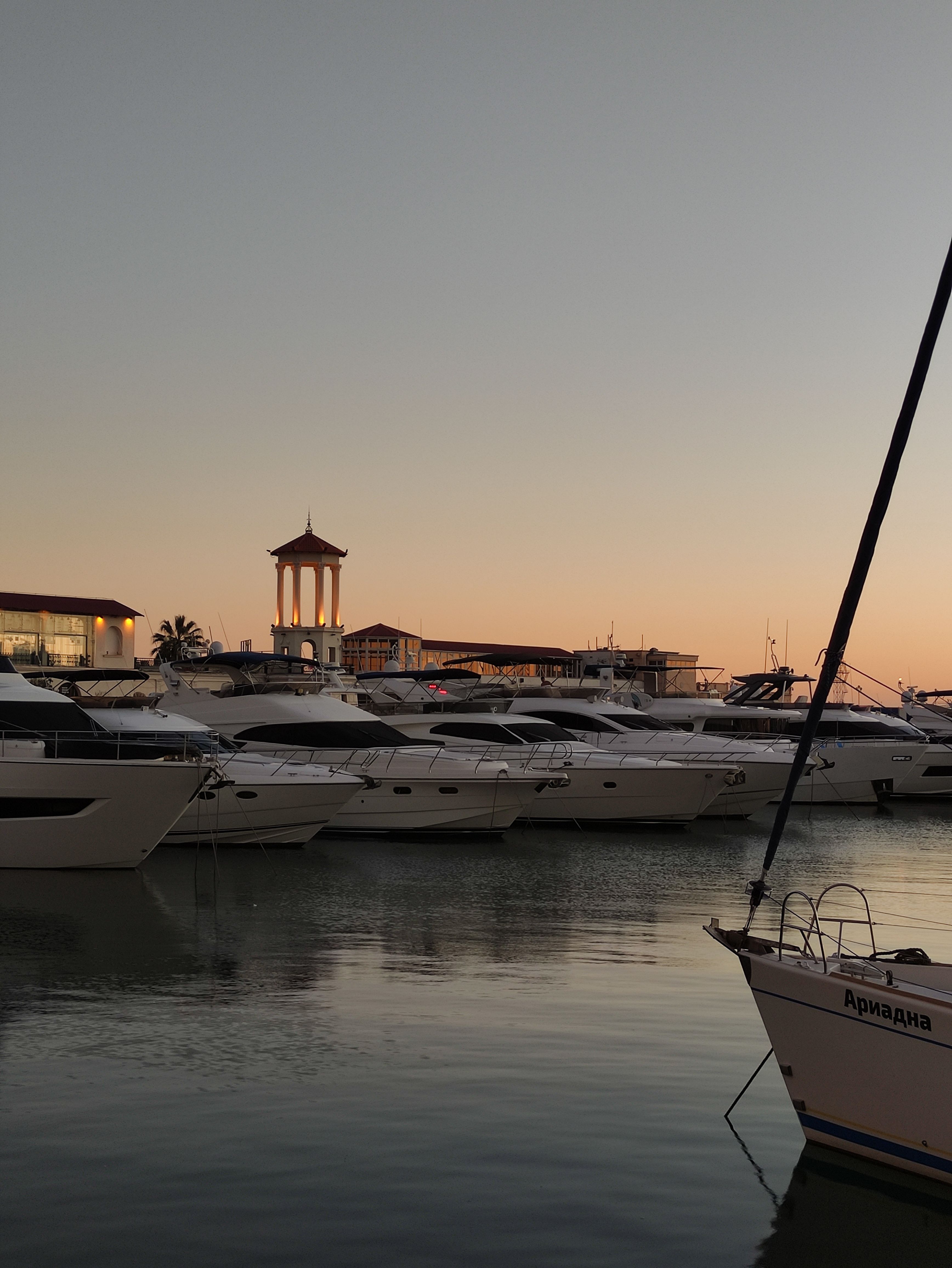 Beautiful marina scene at twilight featuring docked yachts and a serene skyline.