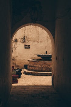 在乡村室内走廊的尽头，有一座复古石喷泉，光线柔和