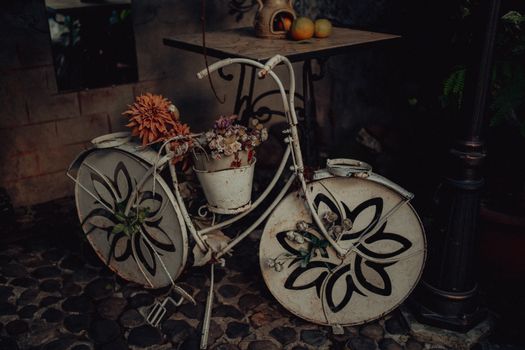 A decorative vintage bicycle planter filled with vibrant flowers, captured in Gürcistan.