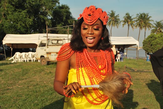Vibrant display of African culture with a woman in traditional attire and jewelry outdoors.
