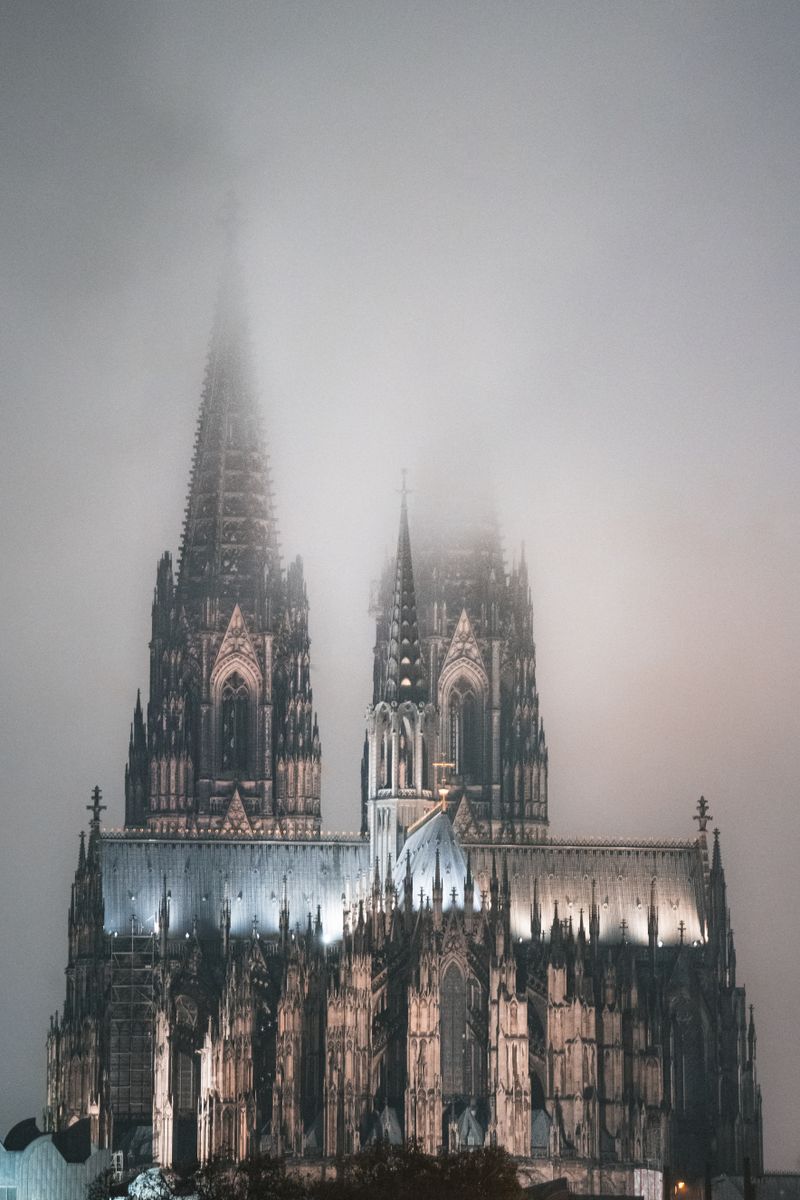 Catedrală gotică învăluită în ceață noaptea, atmosferă de iarnă