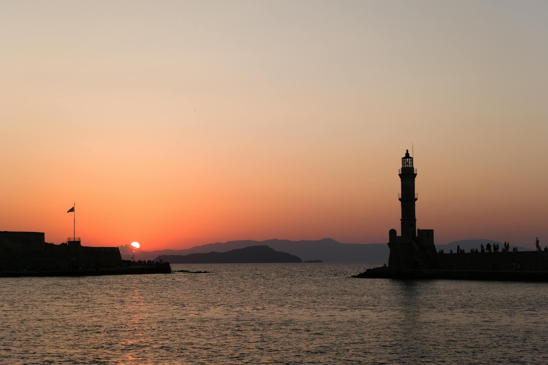 Beautiful sunset view of Chania lighthouse captured from the harbor in Greece.