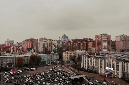 Free Aerial view of urban cityscape with multiple residential buildings and parked cars during dusk. Stock Photo
