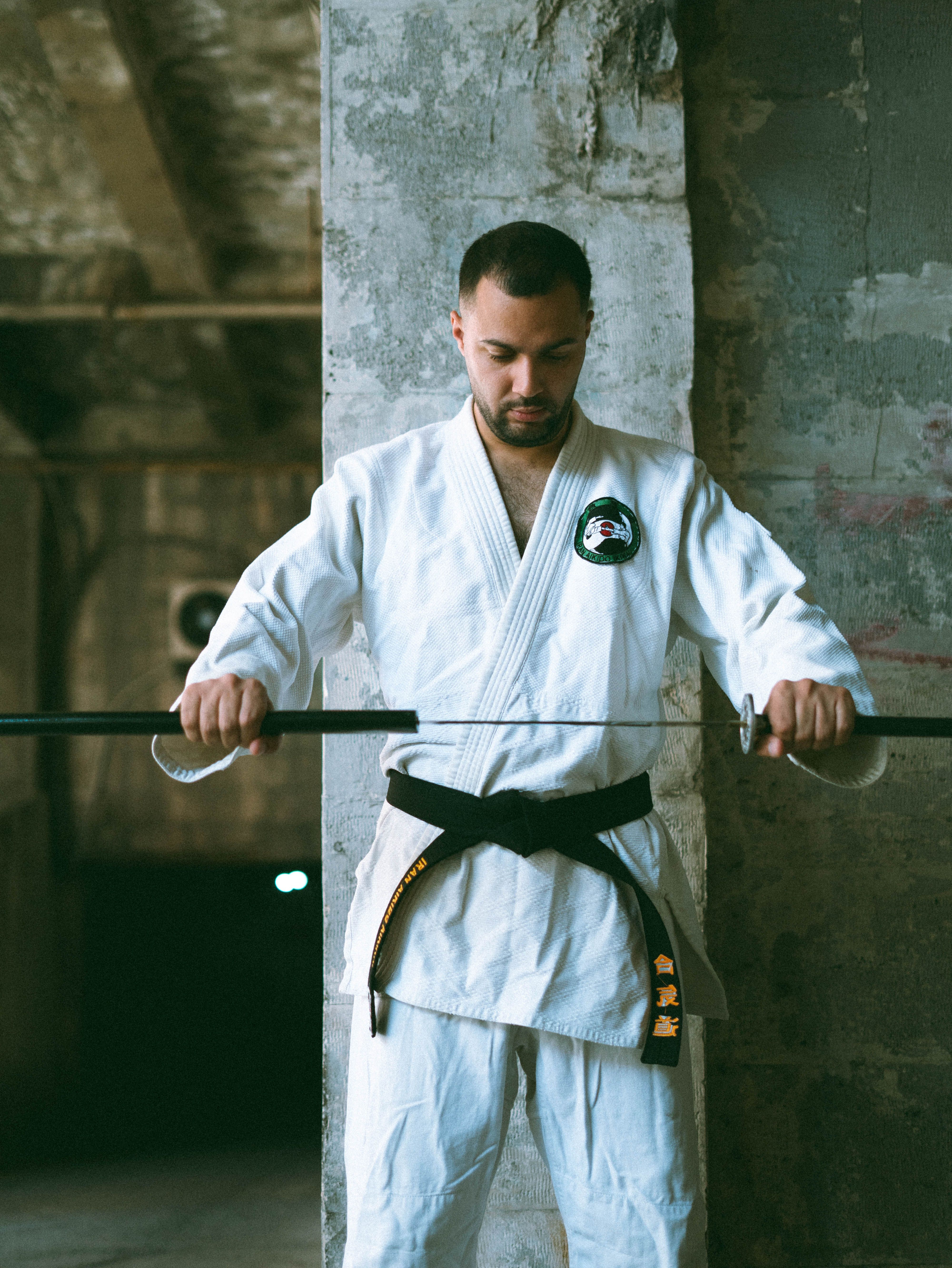 Martial artist focusing on katana practice in an industrial indoor setting.
