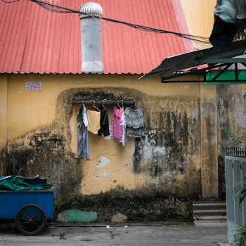Urban residential wall with clothes drying under a red roof, showcasing daily life in Ho Chi Minh City, Vietnam.