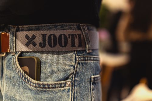 Free Stylish jeans with a branded belt and smartphone, captured at a Berlin fashion event. Stock Photo