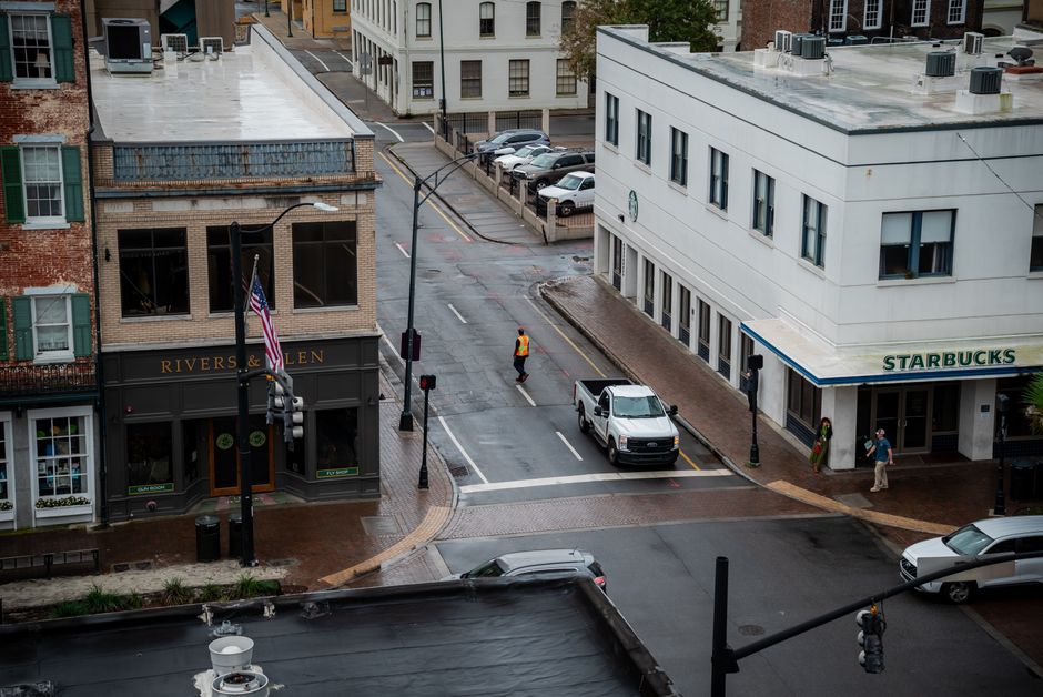 Aerial view of a street corner in downtown Savannah, Georgia, featuring pedestrians and buildings.