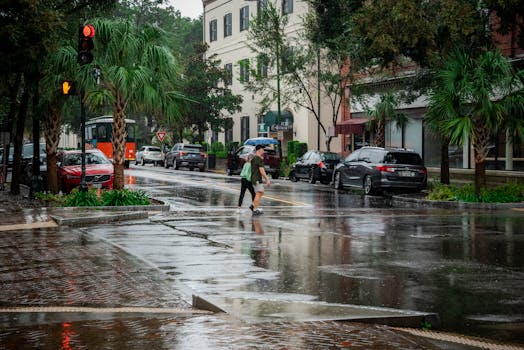 A rainy day in Savannah, Georgia, featuring pedestrians and traffic on a wet street.