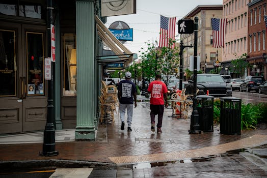 A bustling street scene in Savannah, Georgia, showcasing local shops and American flags.