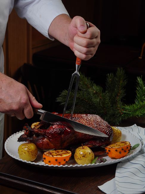 A whole duck roasted at a low, then high, oven temperature for deeply crisp skin and tender meat, with rendered fat saved along the way.