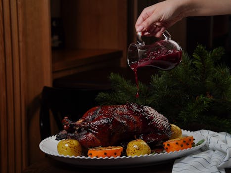 A beautifully roasted duck with cranberry sauce, placed alongside decorated fruits for a festive meal.