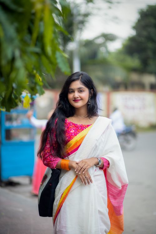 Free A young woman in traditional Bangladeshi attire posing outdoors, showcasing vibrant fashion. Stock Photo