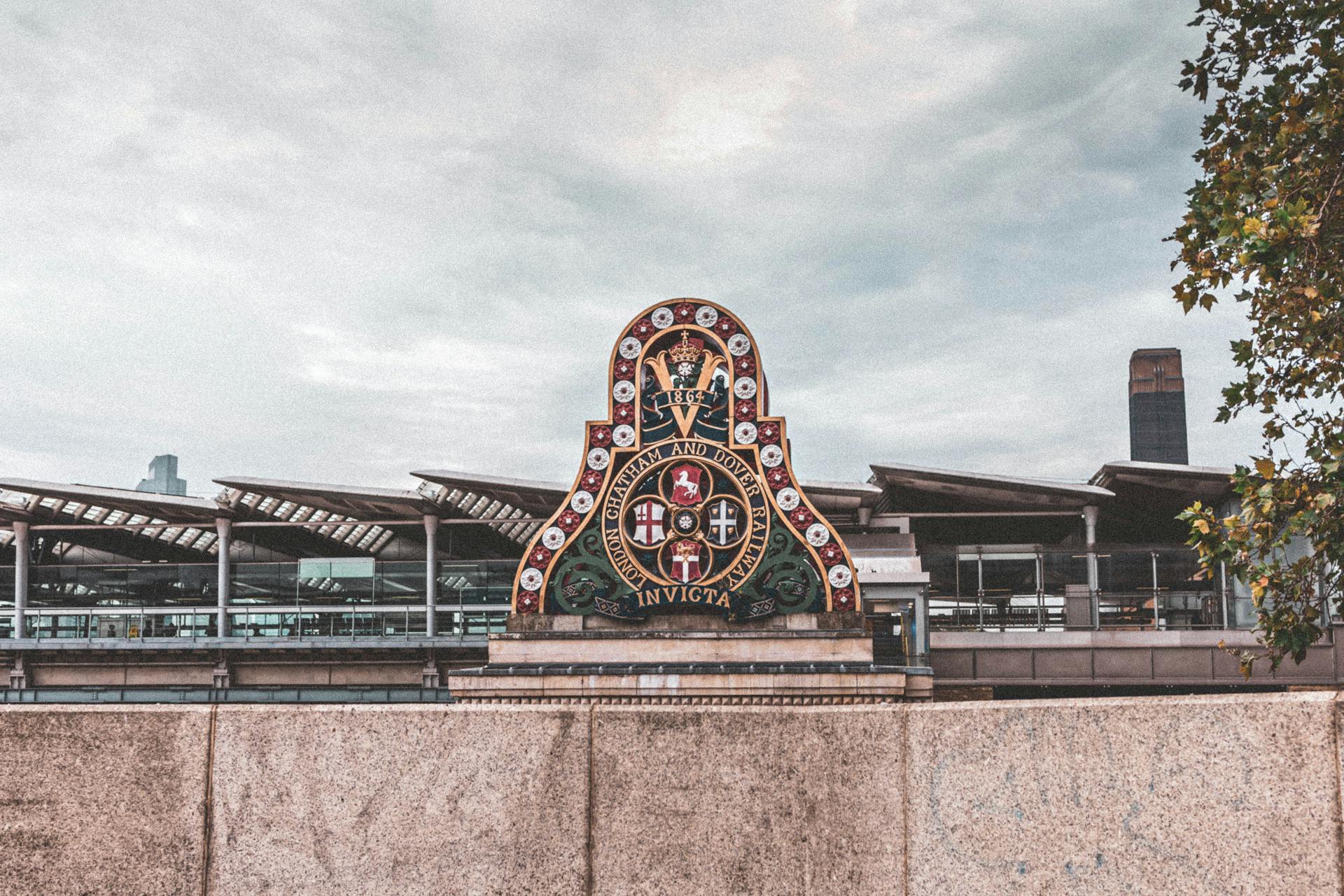 Emblem of Chatham and Dover Railway on a London bridge under an overcast sky.