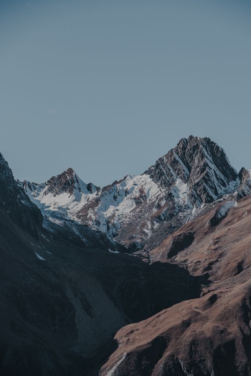Free Stunning view of snow-capped mountain peaks with clear blue sky. Stock Photo