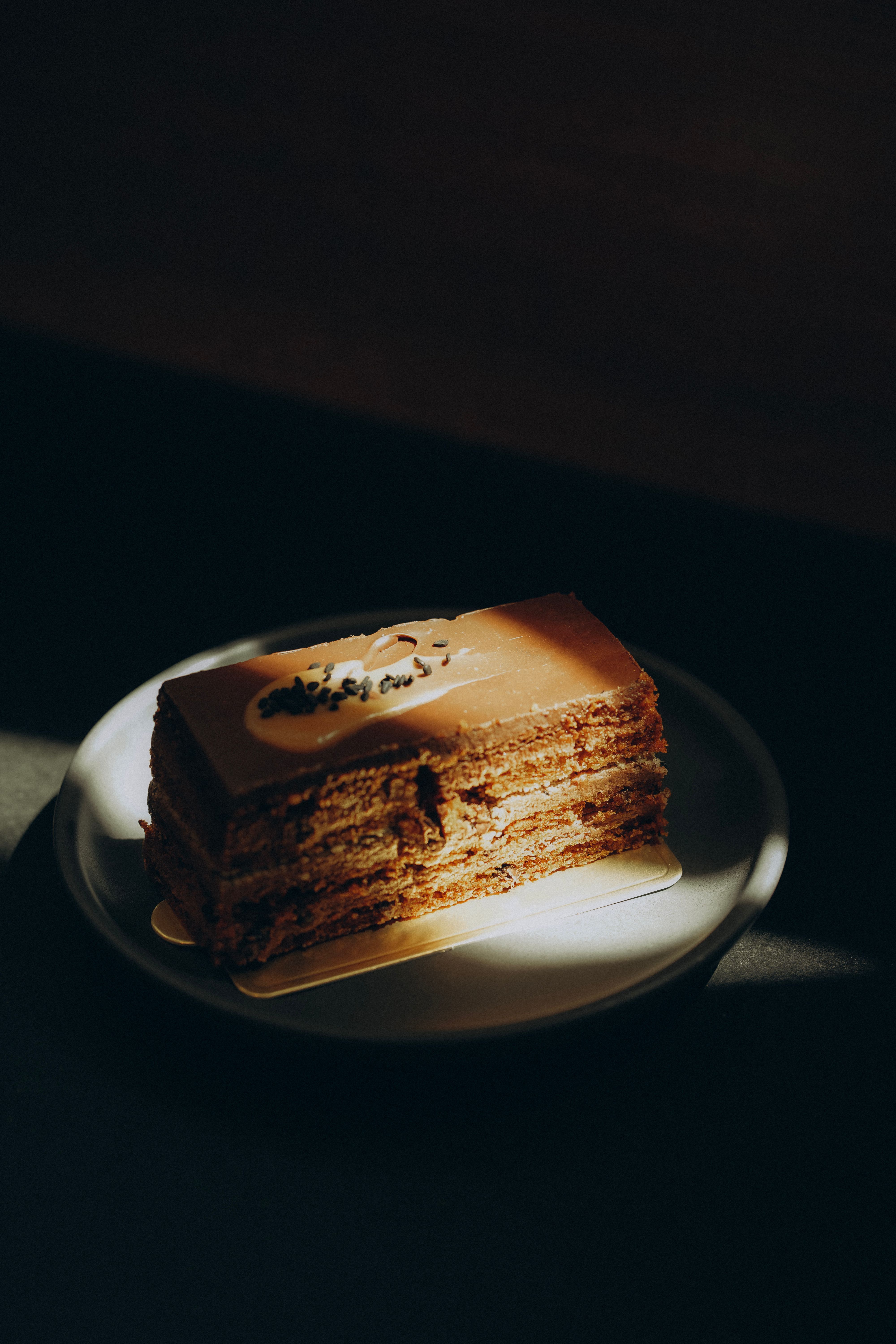A refined chocolate cake slice in warm, moody lighting