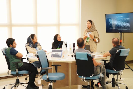 Group of professionals collaborating in an office meeting with presentations.