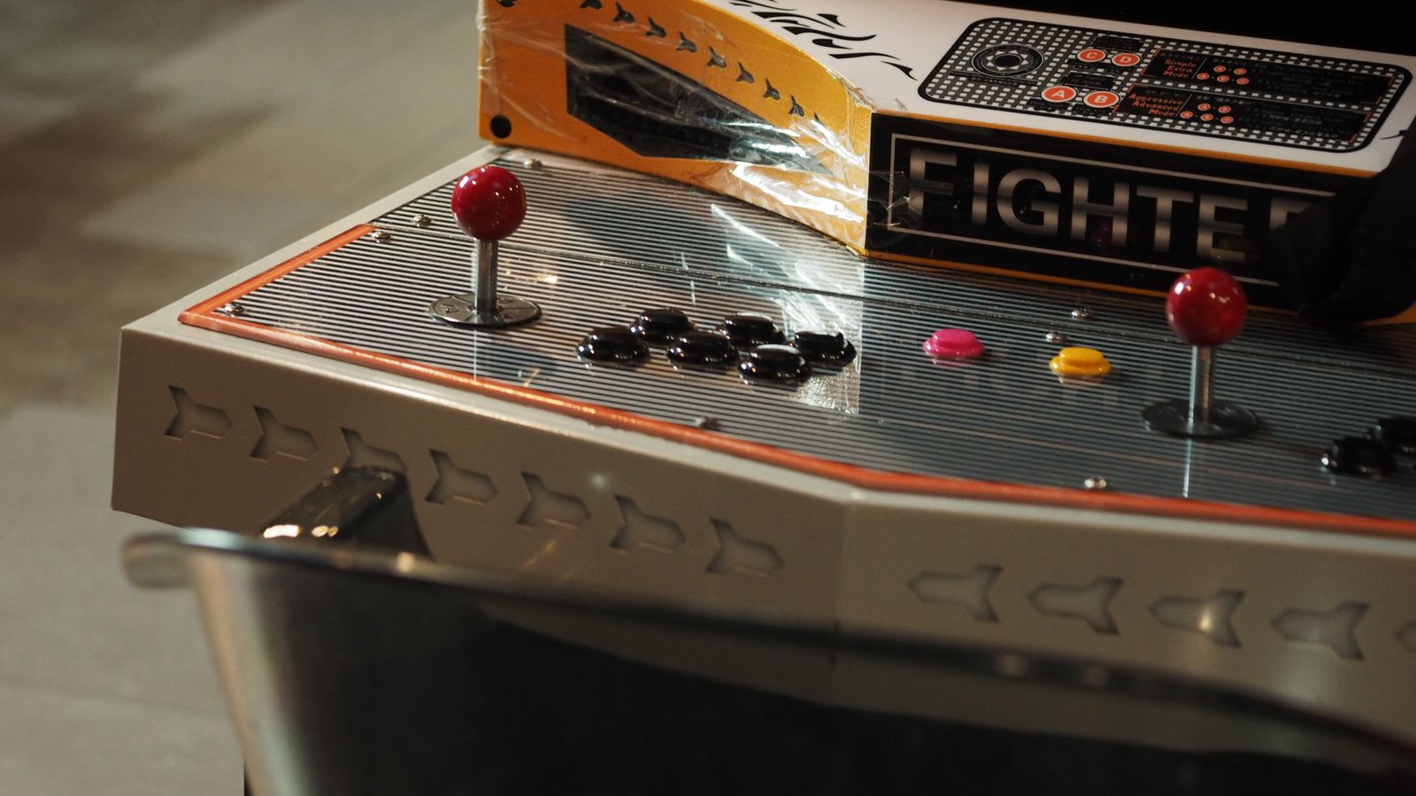 Close-up of a vintage arcade game control panel with joysticks and buttons, a real stock photo with no people in the frame, chosen because Street Fighter began as Capcom's arcade fighting game