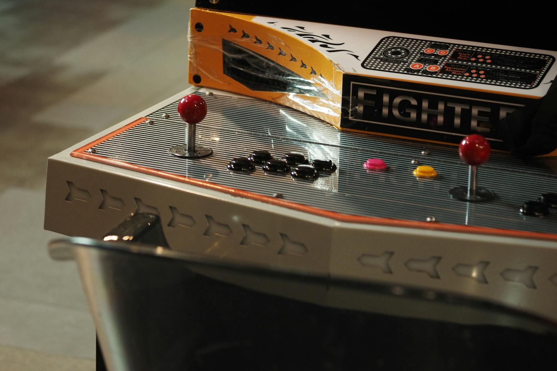 Close-up of a vintage arcade game control panel with joysticks and buttons.