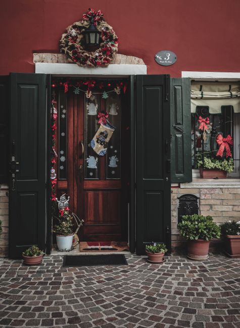 Charming doorway adorned with Christmas wreaths and decorations, exuding festive cheer.