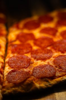 Close-up of a delicious pepperoni pizza slice in a Toronto pizzeria, showcasing rich toppings and thin crust.