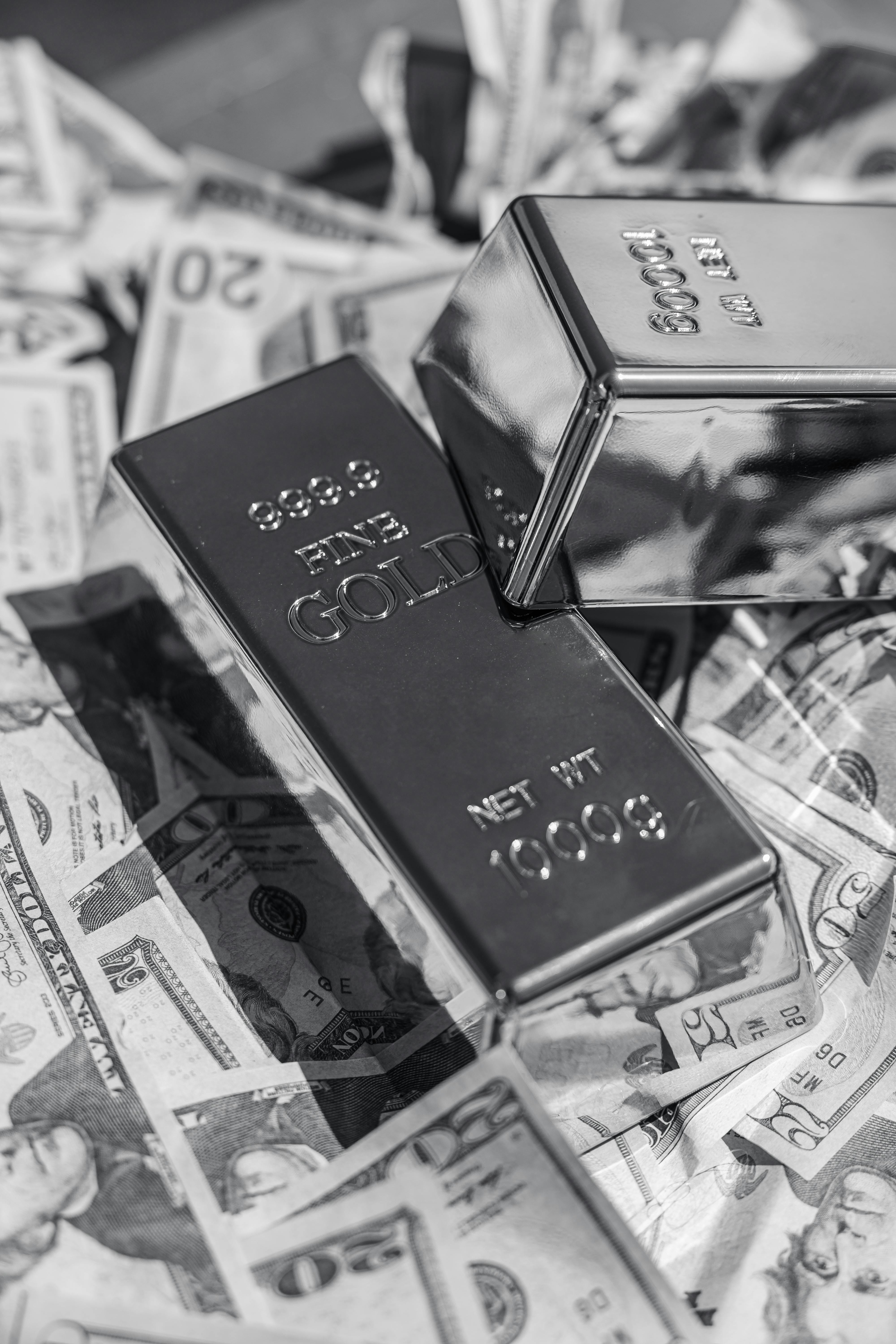 gold bars on us dollar bills in black and white