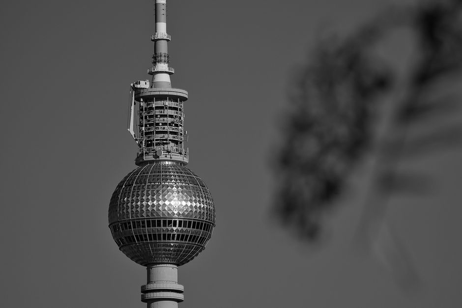 Monochrome close-up of the iconic Berlin TV Tower in daylight, capturing its detailed architecture.