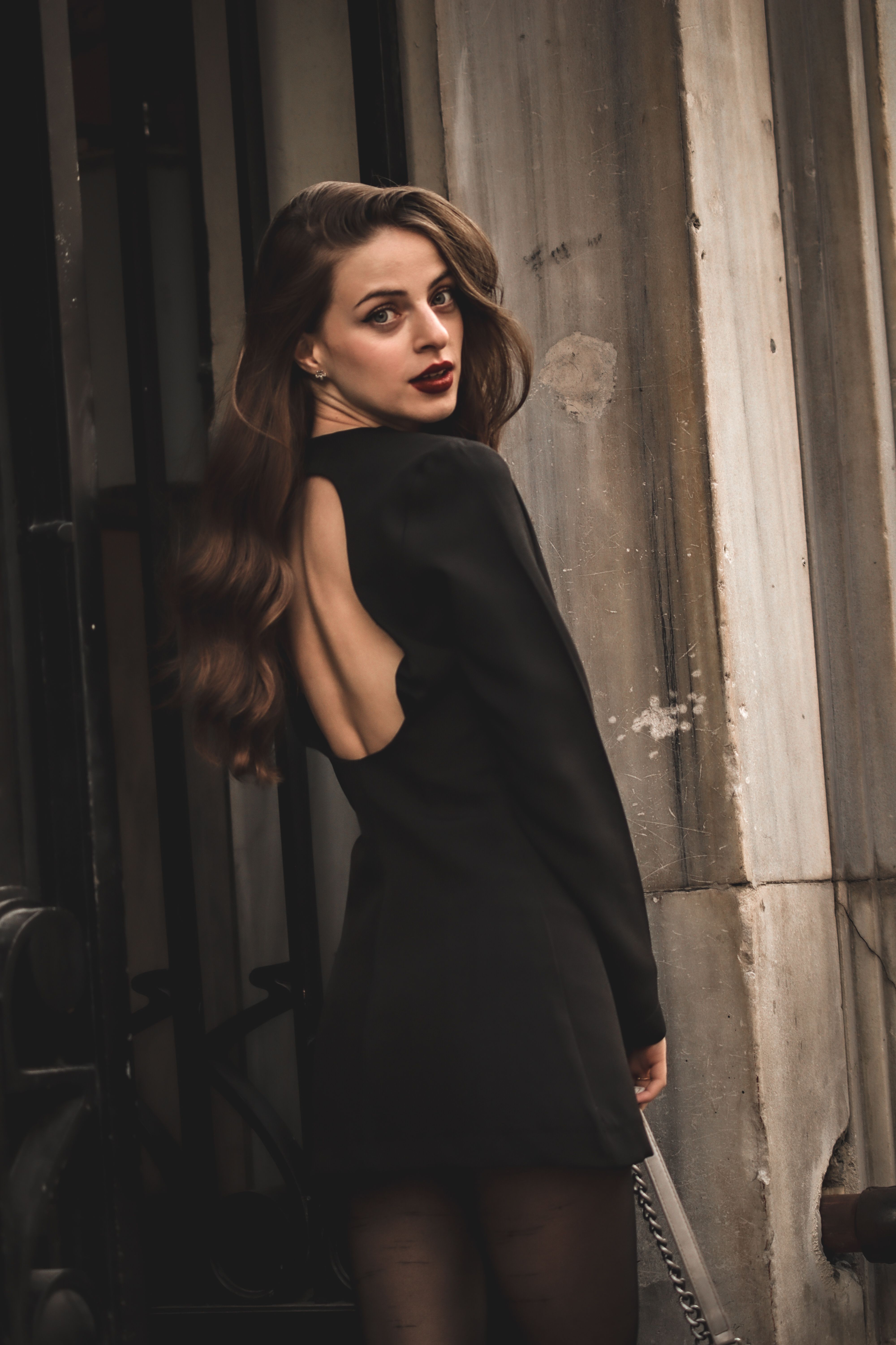 A Woman in Black Long Sleeves Dress Standing on Stairs  Free Stock Photo