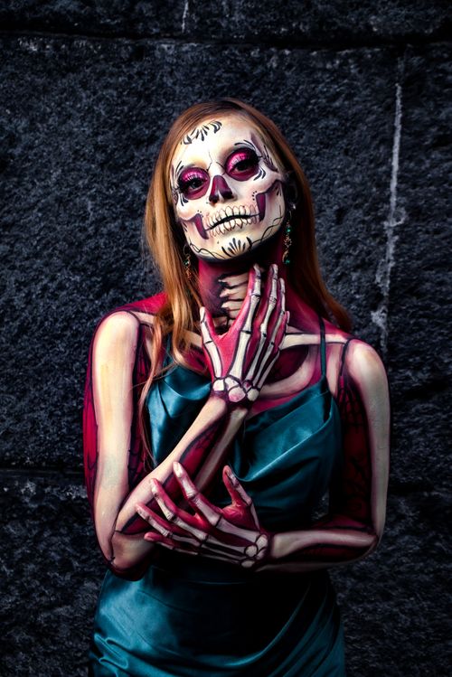 Free A woman in Catrina makeup and skeleton body paint poses dramatically. Stock Photo