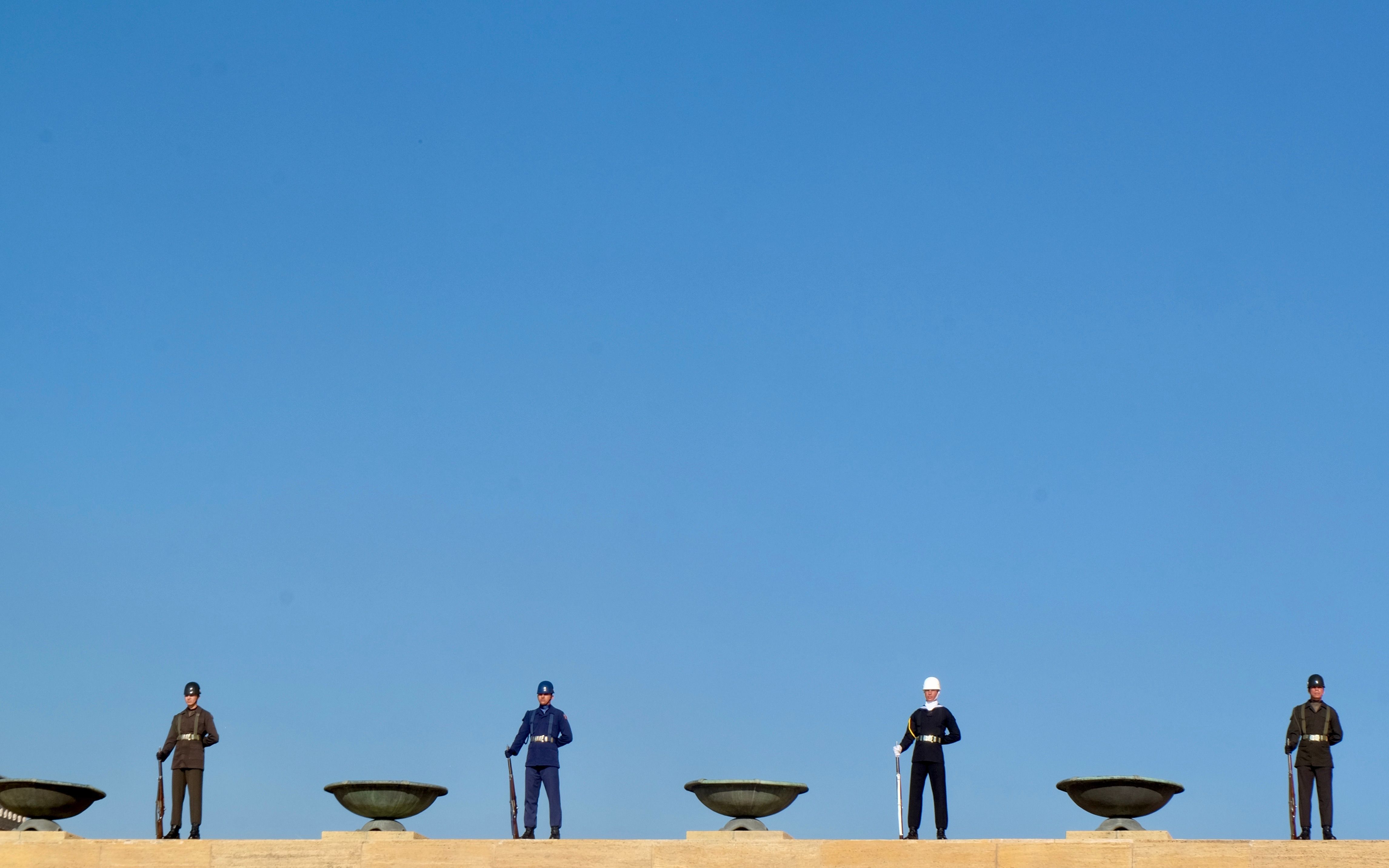 Uniformed guards standing at Anıtkabir in Ankara under a clear blue sky.