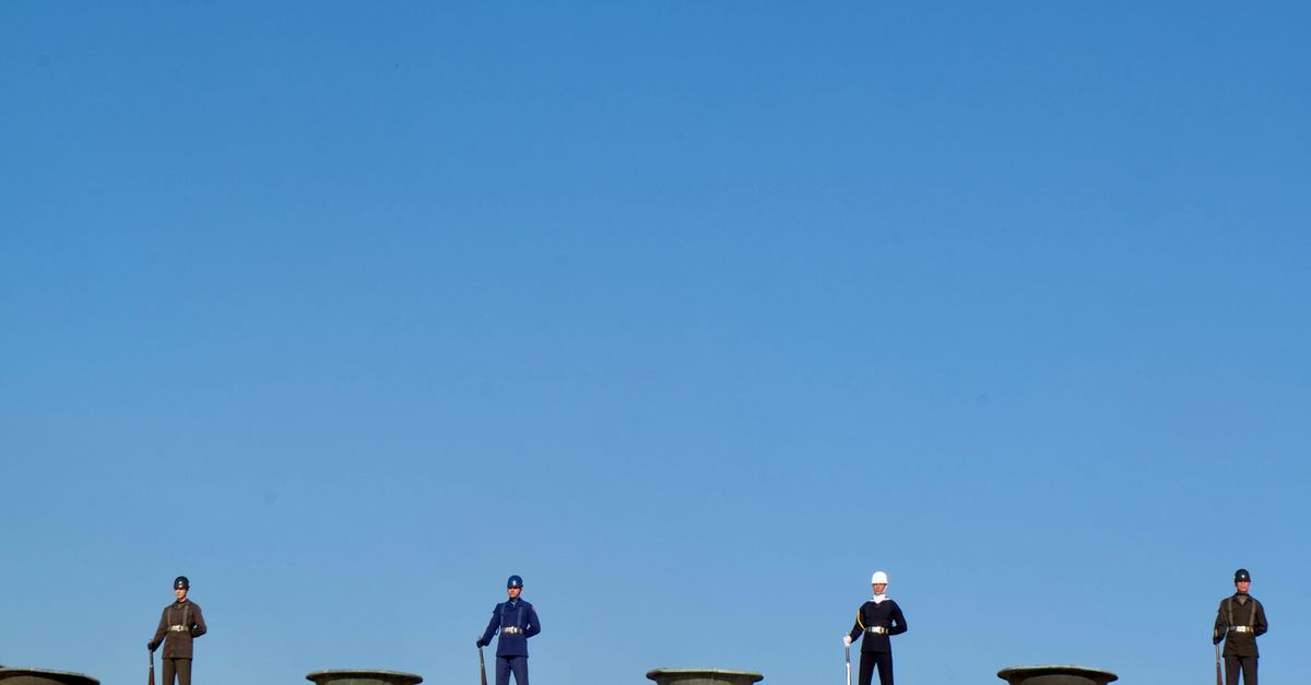 Uniformed guards standing at Anıtkabir in Ankara under a clear blue sky.