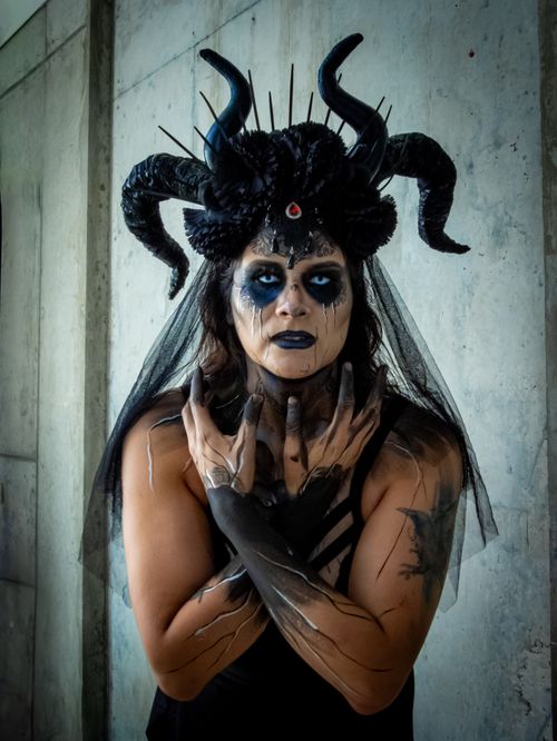 Free A striking portrait of a woman in an elaborate Halloween costume with dark makeup and horns. Stock Photo