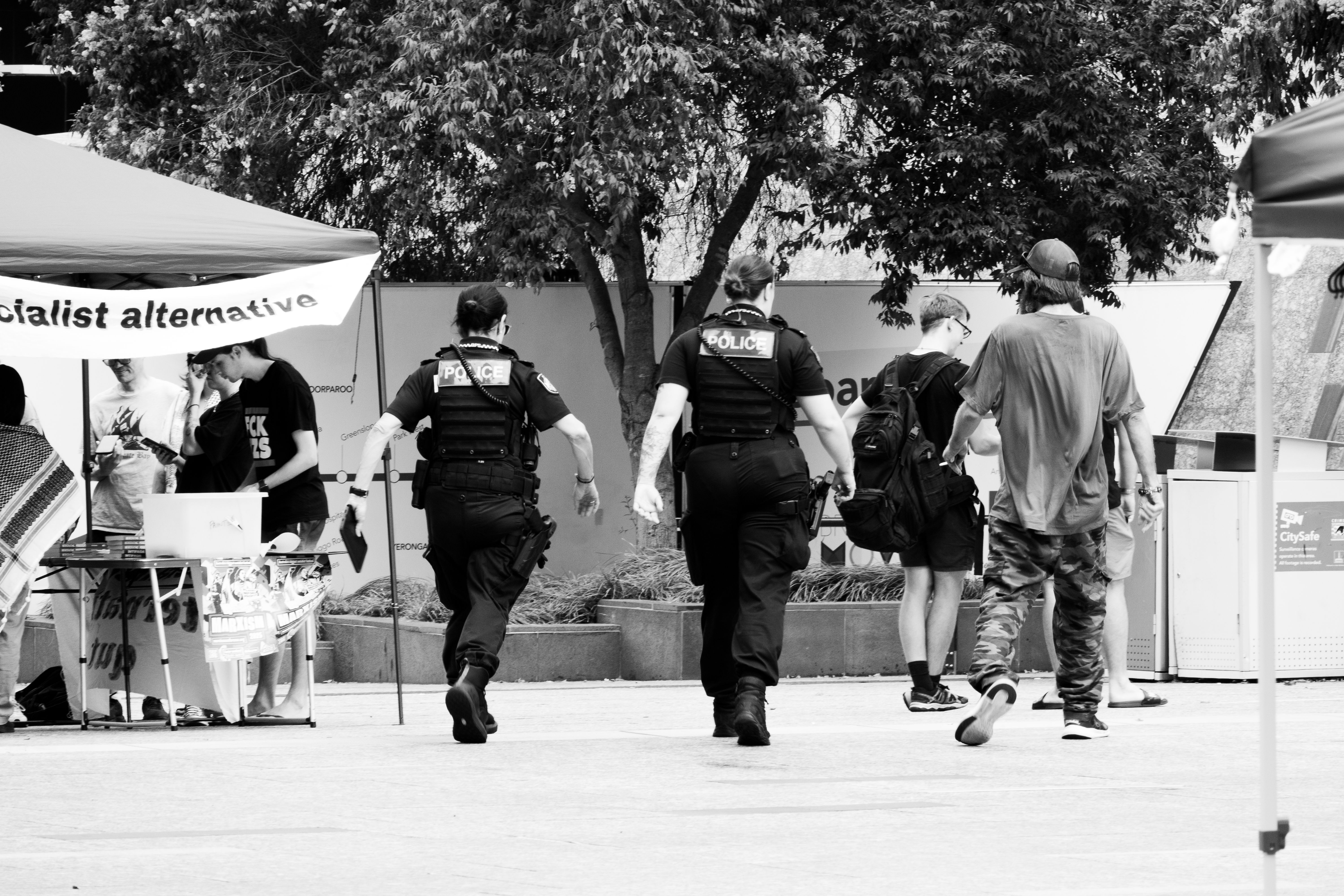 Police officers walking towards protesters in Brisbane, capturing a moment of civil engagement and law enforcement.
