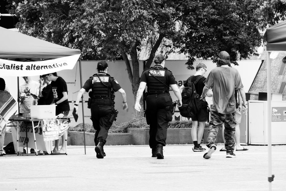 Police officers walking towards protesters in Brisbane, capturing a moment of civil engagement and law enforcement.