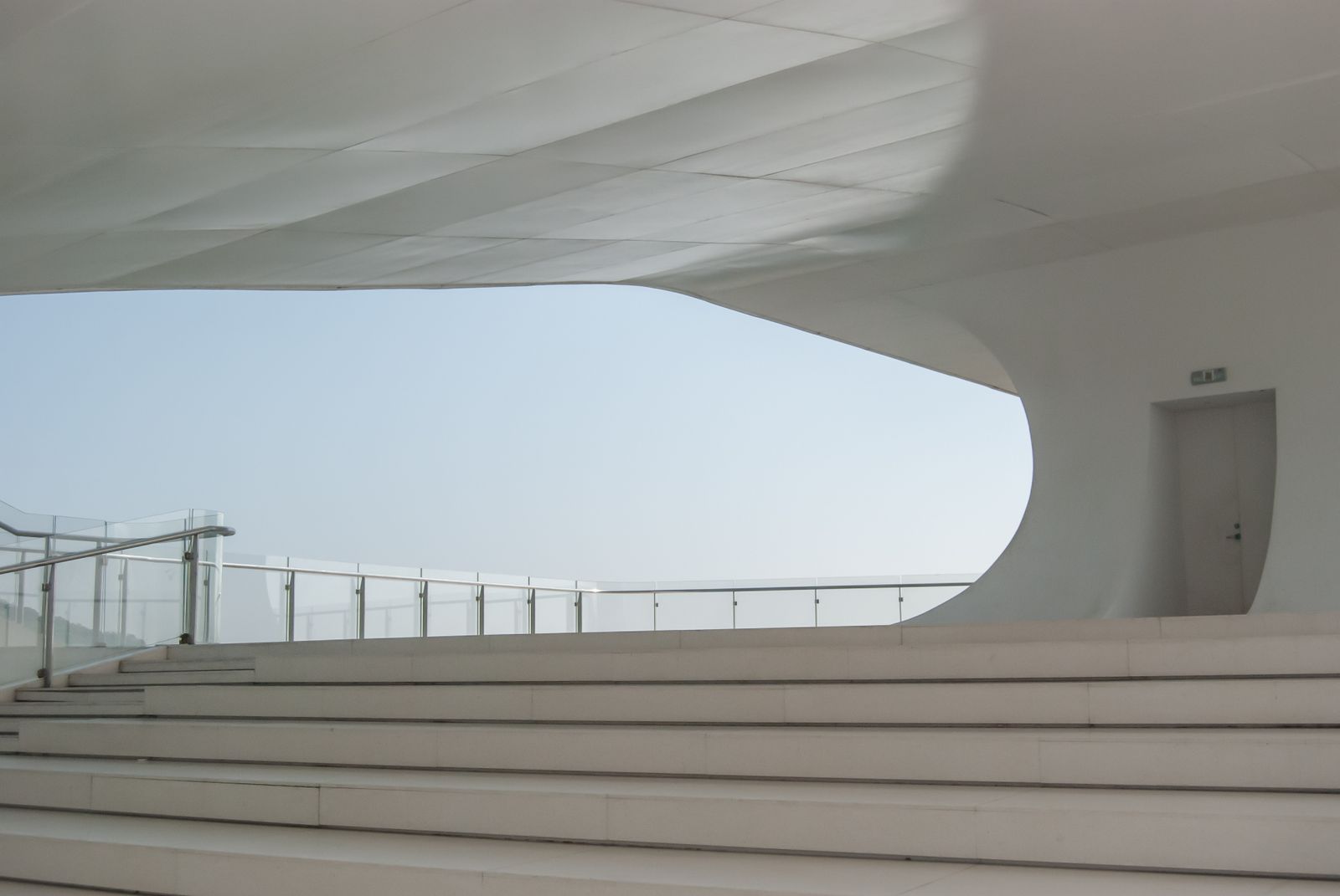 A calm, modern architectural interior with white stairs and open space — the beauty of owning less