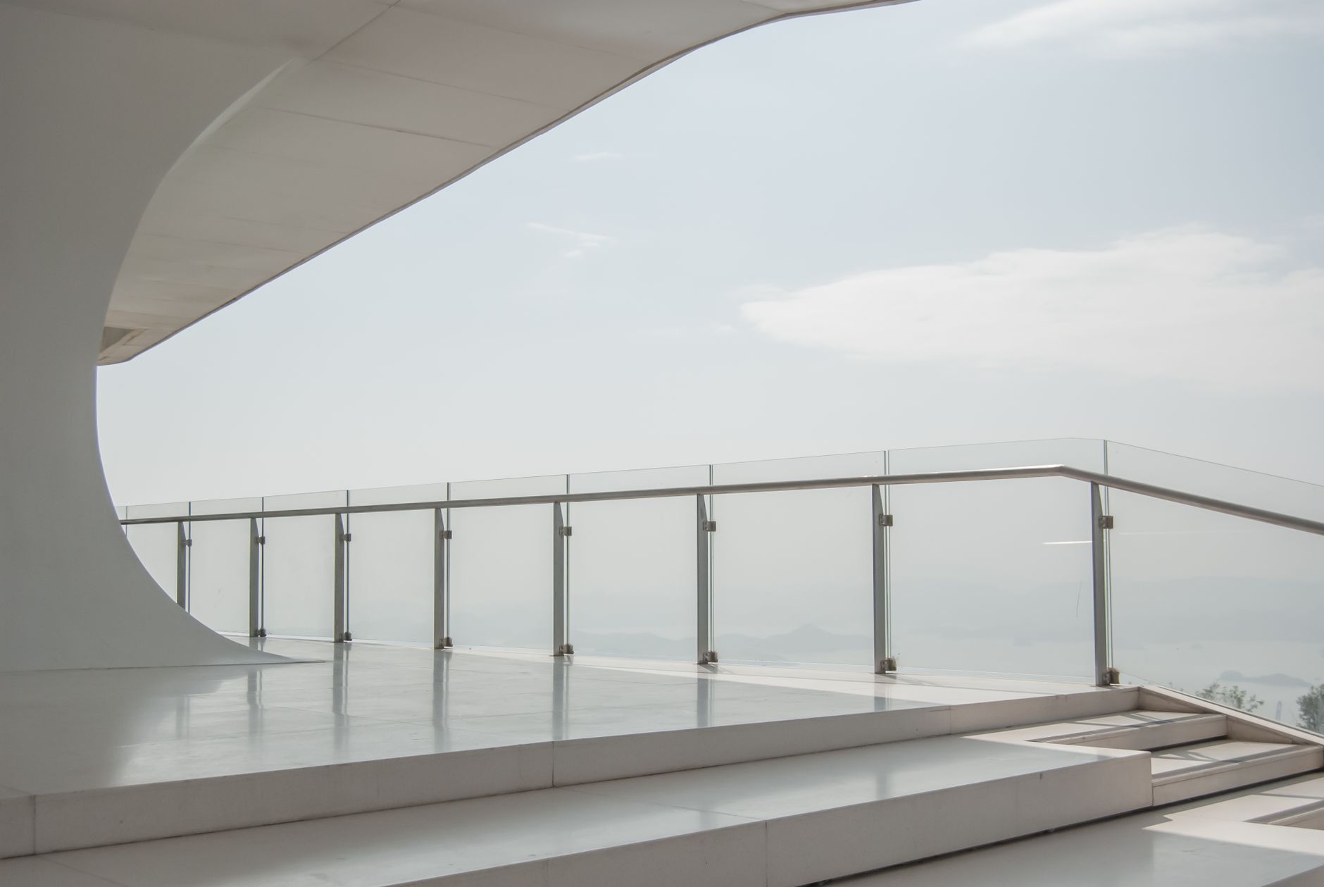 Modern bir yapıda şeffaf cam korkuluk ve minimalist mimari tasarım detayı.