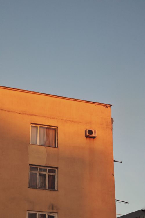 Free A cozy Soviet-era building bathed in golden sunset light, creating a warm ambiance. Stock Photo