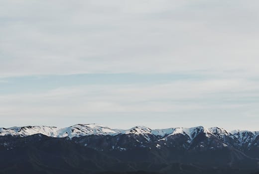 Snow-covered Caucasus mountains in Georgia under a vast blue sky. A breathtaking natural landscape.