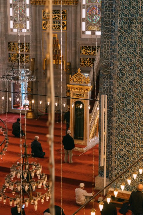 Free Beautiful mosque interior with intricate designs and worshippers during prayer. Stock Photo