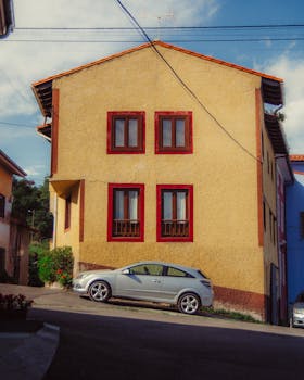 Beautiful rural house in España with red-trimmed windows under a clear sky.