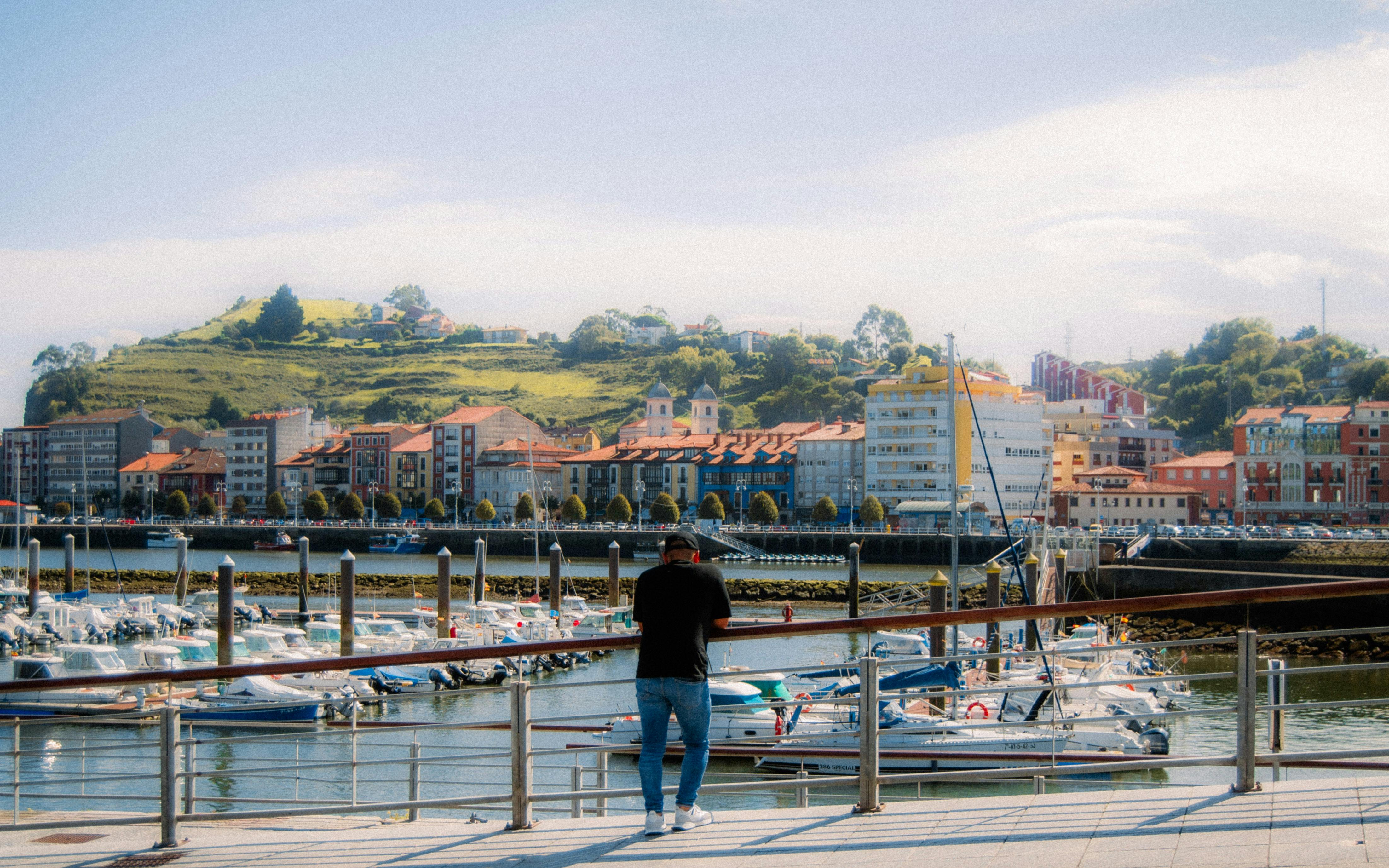 A picturesque view of Gijón Marina in Asturias, Spain, capturing boats against a vibrant cityscape. - Asturias