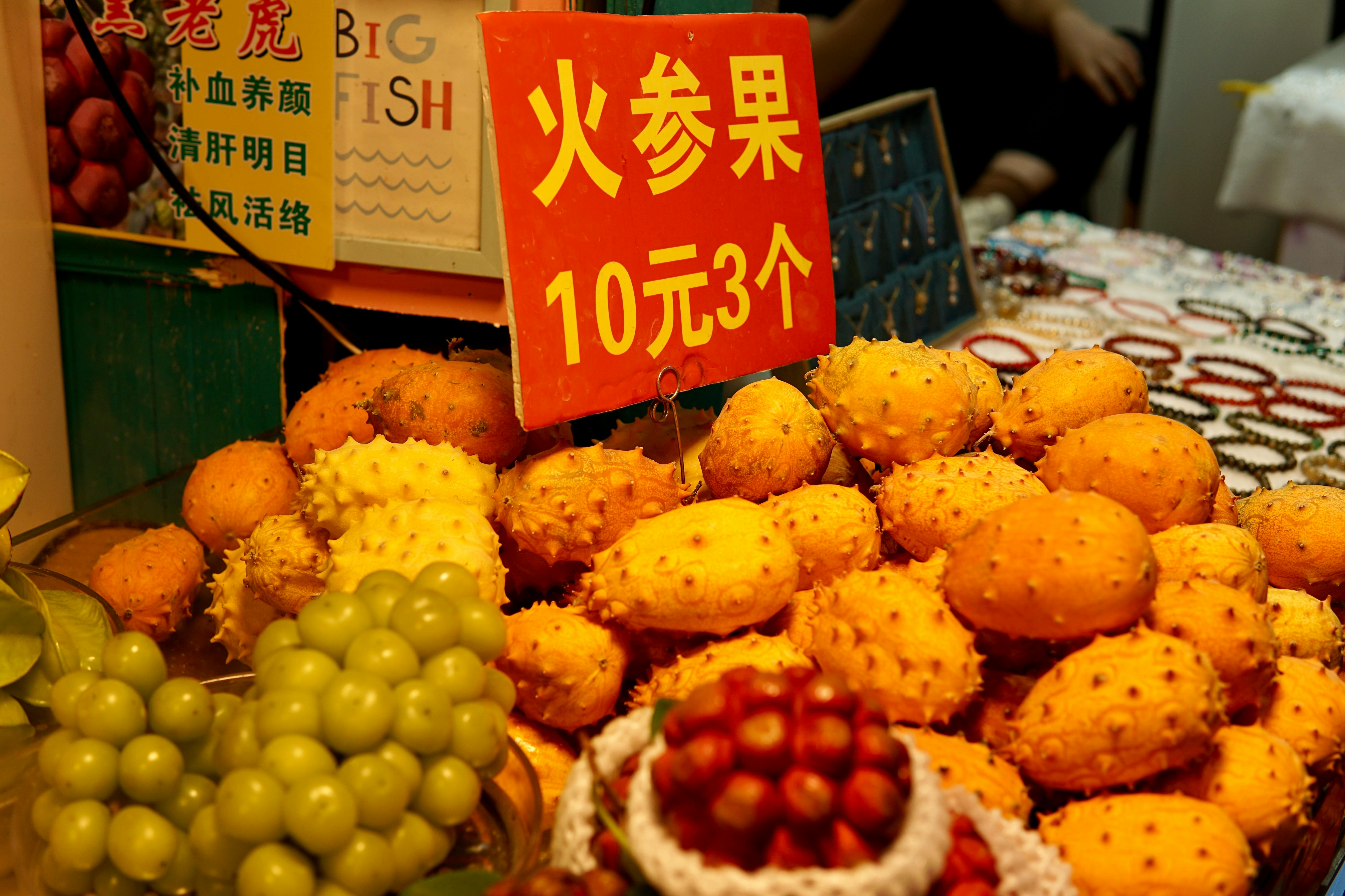 Vibrant market fruits with Chinese signage and prices.