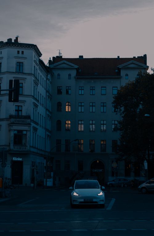 Free Moody evening scene in Berlin with a car on the street and illuminated buildings. Stock Photo