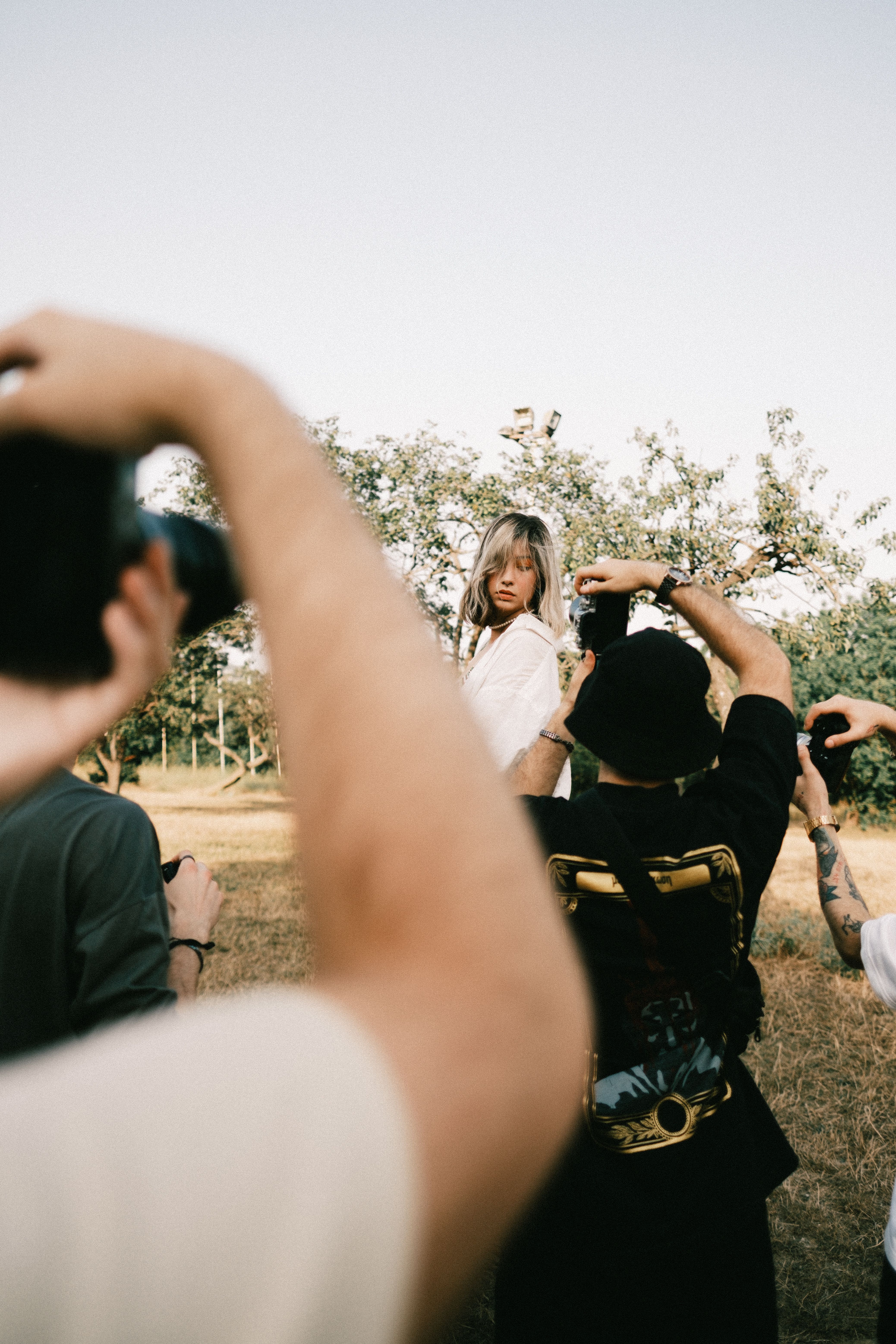 Model poses during outdoor fashion photoshoot with photographers.