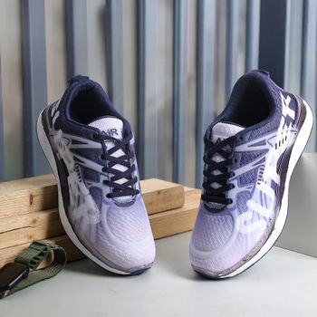 Stylish purple sports shoes displayed against a wooden and metal background in New Delhi.（イメージ）