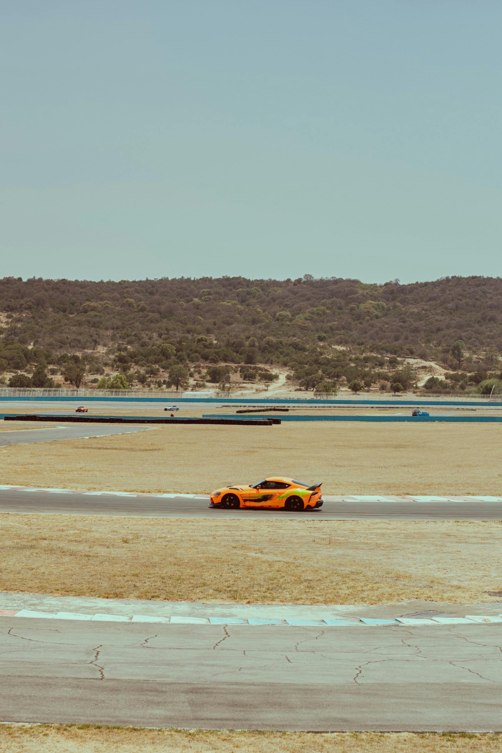 Voiture de sport orange sur circuit — rubrique Lifestyle Driver's Lab